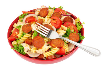 Chorizo and chicken pasta salad bowl isolated on a white background