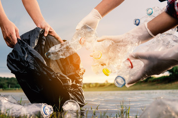 Human picking up a bottle plastic in the river , protect environment from a water pollution concept.