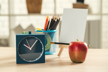 It's time for school. Vintage alarm clock and apple on wooden desk
