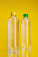 Plastic bottle of mineral water on a bright yellow background