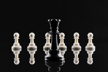 Chess figures on dark black background close up