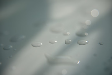drops of water on white surface with shadow
