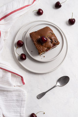 A piece of chocolate brownie with cherry on white background, homemade bakery and dessert. Bakery, confectionery concept. Copy space, top view, vertical, story