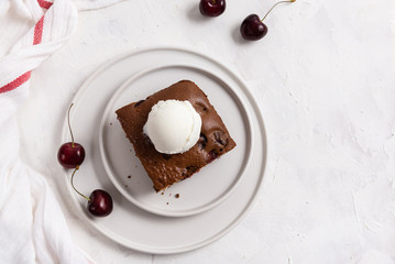 chocolate brownie cake dessert with cherry and ice cream ball on the top on a white background. Copy space, top view. Homemade bakery and dessert. Bakery, confectionery concept.