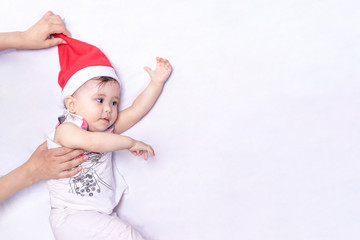 Little Santa. 1-year-old baby girl in Santa Claus hat. Merry Christmas. Adorable middle-eastern girl in Santa cap.