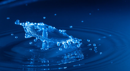 water drop impacting and splashing on a body of water