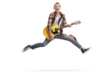 Young male musician playing an electric guitar and jumping - Powered by Adobe