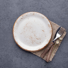 Empty  plate and cutlery on a napkin. Top view