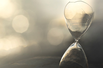 interruption of time measurement in a broken hourglass - obrazy, fototapety, plakaty