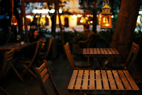 Restaurants and bars on evening streets. Lights of the evening city, calm evening of a business day