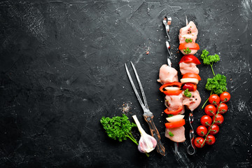 Raw chicken shish kebab with vegetables and spices. Top view. Free space for your text. Rustic...