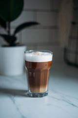 Coffee latte macchiato with vegan coconut milk in a glass