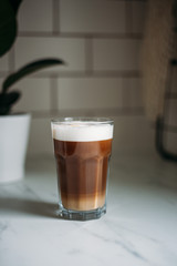 Coffee latte macchiato with vegan coconut milk in a glass