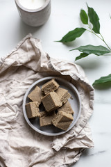 Portion of halva with vanilla and sunflower seeds on marble background with copy space