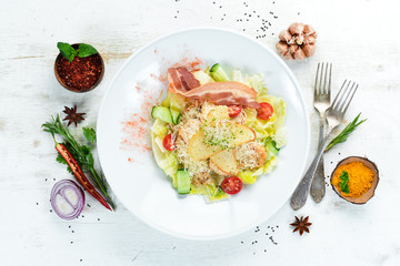 Vegetable Caesar Salad with Bacon. On a wooden background. Top view. Free space for your text.