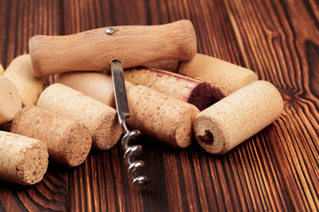 Corkscrew with cork. On a wooden background. - Image