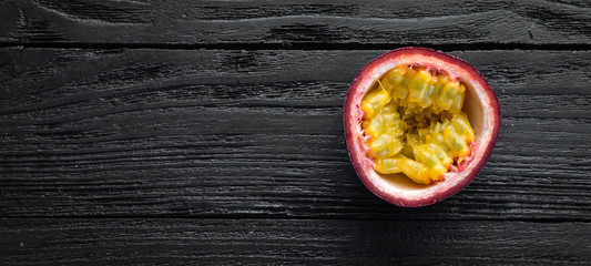 Passion fruits on a wooden background. Tropical Fruits. Top view. Free space for text.