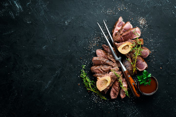 Osso buco cooked Veal shank on a black background. Top view. Free space for your text.