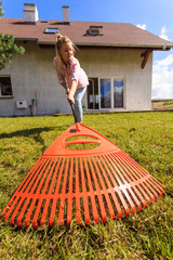 Unusual angle of woman raking leaves