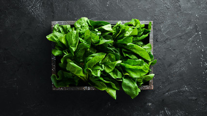 Spinach in a wooden box. Healthy food. Top view. Free space for your text.