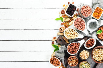Assorted nuts on a white wooden background. Top view. Free space for your text.
