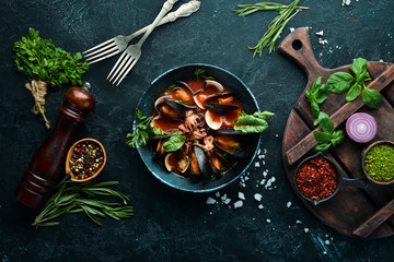 Tomato soup with seafood. Mussels, clams and octopuses. In the old background. Top view. Free copy space. - obrazy, fototapety, plakaty