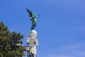 Sculpture of a wing angel in front of a blue sky in Vienna, Austria