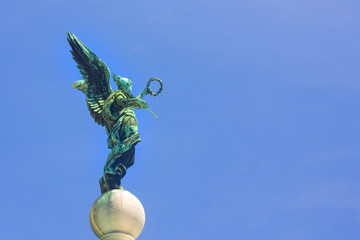 Sculpture of a wing angel in front of a blue sky in Vienna, Austria
