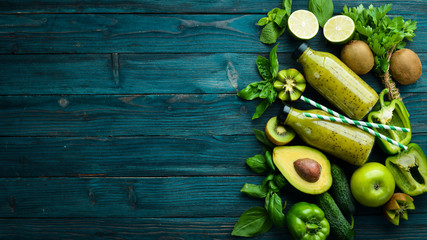 Healthy Green food. Fruits and vegetables - avocado, lime, onion, apple, kiwi, spirulina. On a blue wooden background. Top view. Free space for your text.