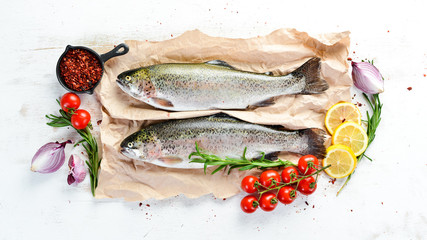 Raw fish on a white wooden background. Fish trout. Top view. Free space for your text.