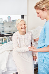 Altenpflegerin hilft Senior Frau beim Aufstehen