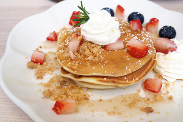Pancakes sprinkled with strawberries and blueberries