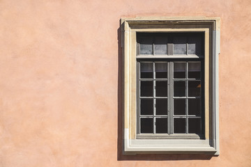 Fototapeta na wymiar One white window of an orange ancient building