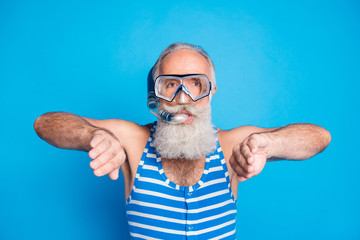 Close up photo of funky man swimming breaststroke with snorkel gear wearing striped swim wear isolated over blue background