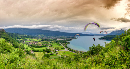 Paragliders with parapente jumping  near of lake of Annecy in French Alps, in France.