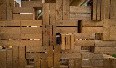 Celosía de madera compuesta por cajas de madera antiguas creando un mosaico decorativo.