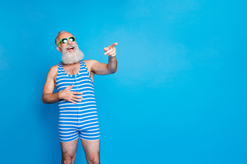 Portrait of nice attractive funky cheerful cheery glad gray-haired man pointing at funny thing news...