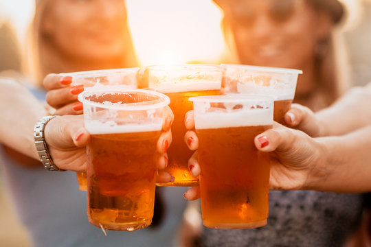 Female Friends Cheering With Beer At Music Festival