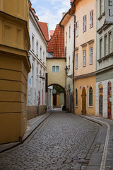 Empty cobblestoned Vejvodova Street and old buildings at the Old Town (Stare Mesto) district in Prague, Czech Republic.