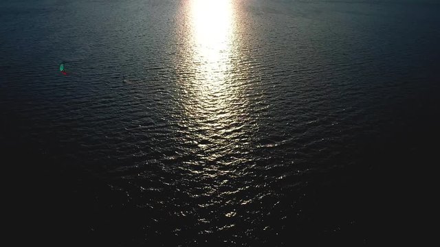 Aerial 4k - kitesurfer in azione al tramonto