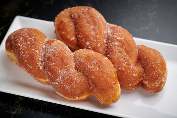 Braided brioches on a white rectangular plate