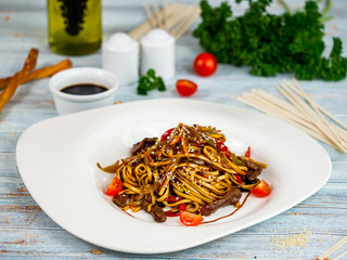 Egg noodles with vegetables and chicken. Restaurant serving.