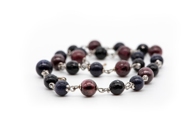 Bracelet made of black agate, garnet and blue aventurine on a white background. Natural stone jewelry.