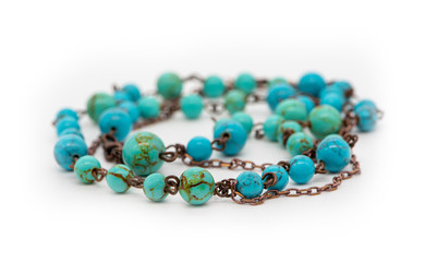 Bracelet made of blue turquoise stone on a white background, close-up, selective focus.