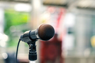 Close up of microphone on abstract blurred background in conference room or concert hall