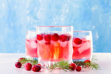 Winter non alcoholic cocktail with cranberry and ice on wooden background, closeup, top view