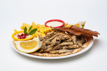 Grilled Sardines plate served with sauce, hummus dip and fries isolated on white background