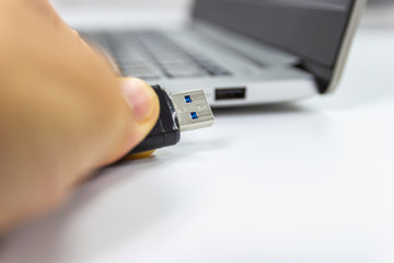 hand man hold Flash drive connect to USB port Laptop computer