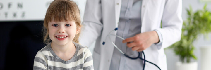 Smiling cute little patient interacting with female doctor portrait