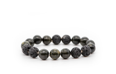 Bracelet made of volcanic lava and serpentine on a white background. Natural stone jewelry.